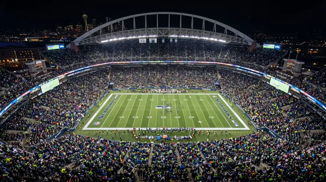 Vista de un estadio de fútbol americano con ambiente nocturno durante un partido de la NFL